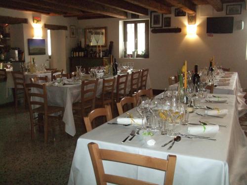 jadalnia z długimi stołami z białymi obrusami w obiekcie Agriturismo Frascje Dai Spadons w mieście Pradamano