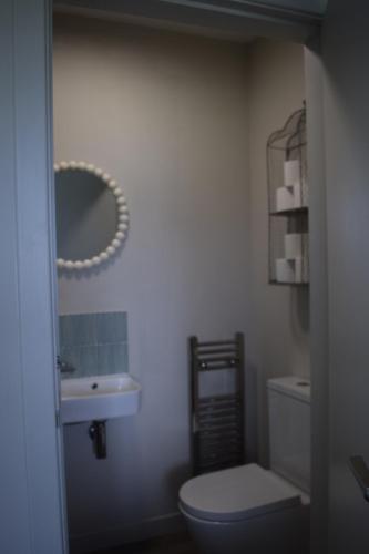 a bathroom with a toilet and a sink and a mirror at Spacious home in Machrihanish in Machrihanish