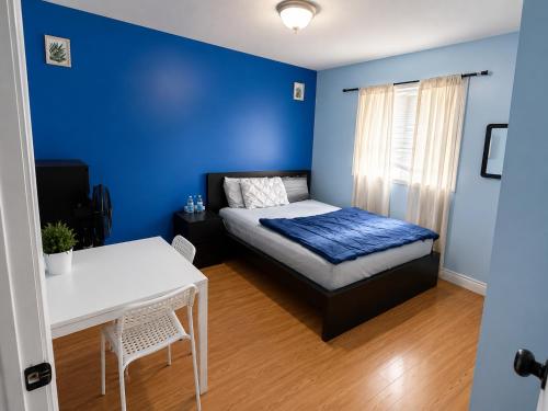 a blue bedroom with a bed and a table at one bedroom in Brampton in Brampton