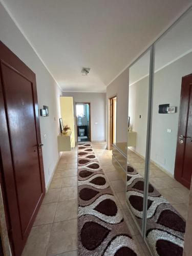 a hallway with a door and a rug on the floor at Apartment golem in Durrës