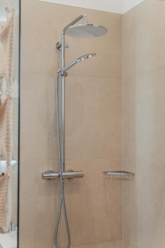 a shower with a shower head in a bathroom at MiHome - modern Living in Rottenmann