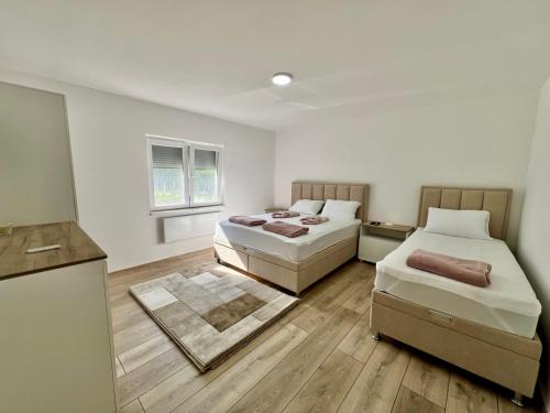 two beds in a small room with a kitchen at Apartmani Milojević in Boljevac