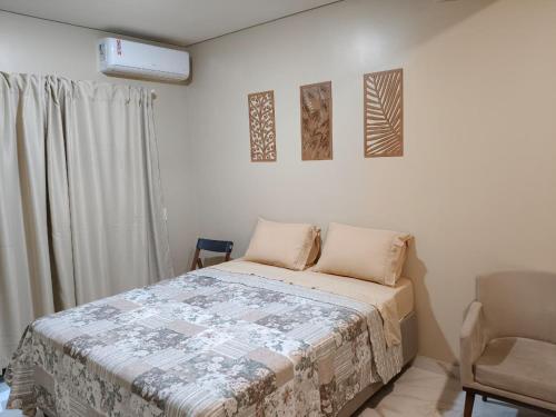 a bedroom with a bed and a chair at Hospedaria Lençóis in Barreirinhas