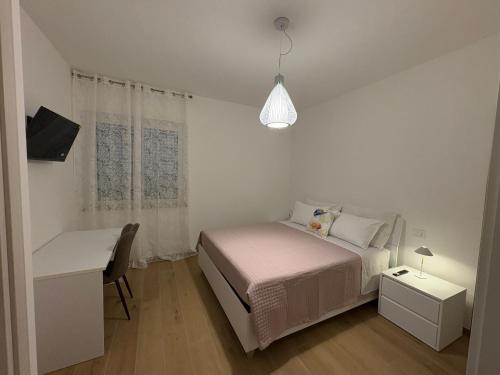 a white bedroom with a bed and a desk at Colombo Boutique Rooms in Tortoreto Lido