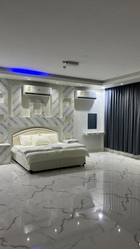 a bedroom with a large bed and a marble floor at فندق الحزم الرستاق Alhazm Hotel Alrustaq in Ḩazm