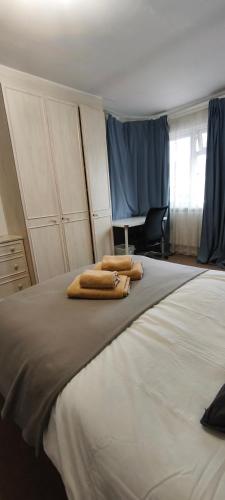 a bedroom with a large bed with two towels on it at Standard Double Room with Shared Bathroom in London