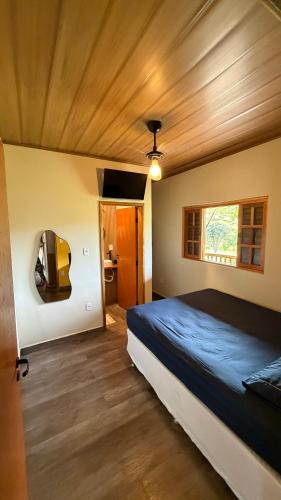 a bedroom with a large bed and a window at Recanto do curio in Aparecida