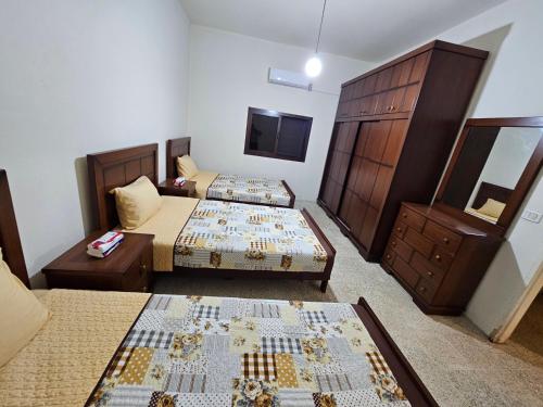a hotel room with two beds and a dresser at Moufid villa in Al Mīdān