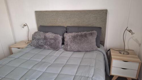 a bed with two pillows on it with two lamps at Apartment Z Alberdi Home in Belén de Escobar
