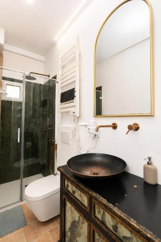 a bathroom with a sink and a toilet and a mirror at Gato street, Private rooms in Madrid