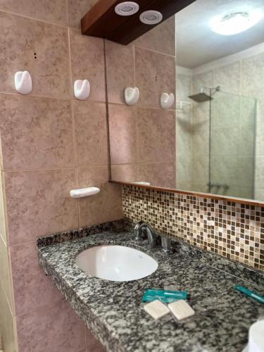 a bathroom with a sink and a mirror at Marchetti Hotel Comedor in Miramar