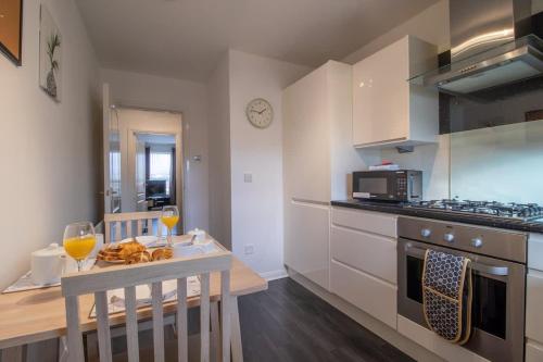 a kitchen with a table and two glasses of wine at Park View-modern 2 bed apartment in Motherwell