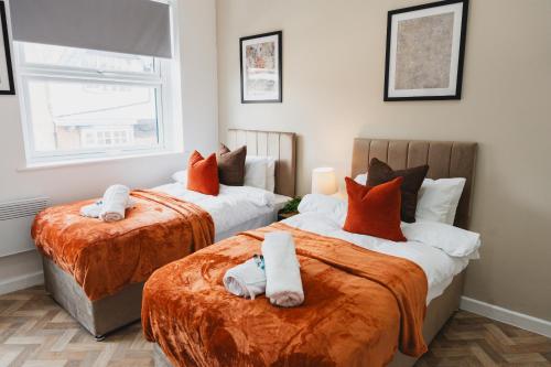 a bedroom with two beds with towels on them at The High Town Suite in Luton