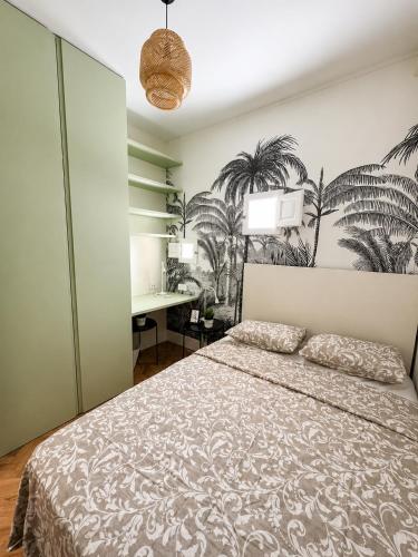 a bedroom with a bed with a desk and palm trees on the wall at Gato street, Private rooms in Madrid