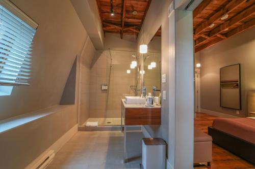 a bathroom with a sink and a tub at Le Pleasant Hôtel in Sutton