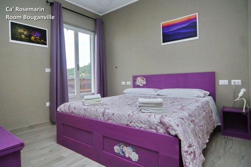 a purple bedroom with a purple bed and a window at Ca' RoseMarin in Cogorno
