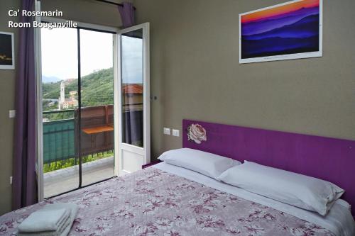 a bedroom with a large bed and a balcony at Ca' RoseMarin in Cogorno
