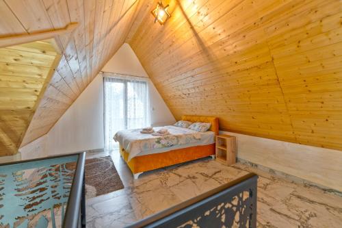 a bedroom with a bed in a wooden ceiling at Brvnara Mont 1 in Zlatibor