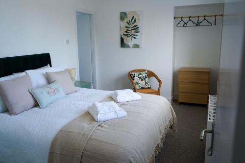a bedroom with a large bed with towels on it at Park House - 3 bedroom in Portsoy