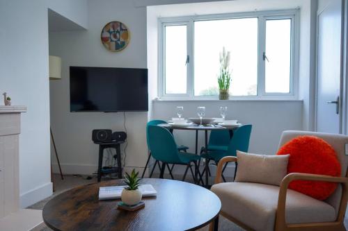 a living room with a table and a couch and a chair at Park House - 3 bedroom in Portsoy