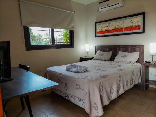 a bedroom with a bed and a table and two windows at Hotel Urbana in Córdoba