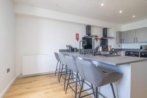 a kitchen with a bar with stools in a room at Alexandra Apartment - Single Room #1 in Falkirk