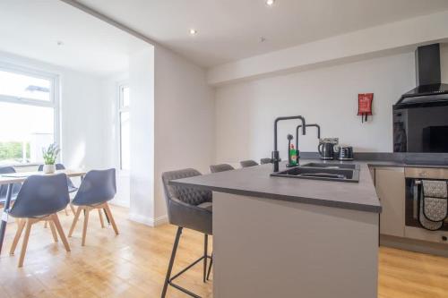 a kitchen and dining room with a counter and chairs at Alexandra Apartment - Single Room #1 in Falkirk