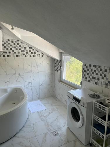 a bathroom with a sink and a washing machine at Amra in Počitelj