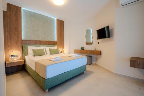 a bedroom with a large bed and a television at Nautilus Villa - Private Pool II in Elaía