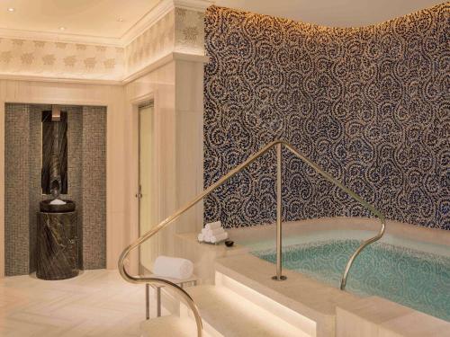 a bathroom with a bath tub in a room at Raffles Singapore in Singapore