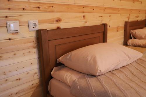 a bed in a room with a wooden wall at Hotel - Old Ushguli in Ushguli
