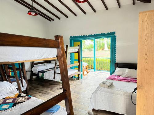 a room with two bunk beds and a door to a yard at El Rincón del Sol y Luna in Quimbaya