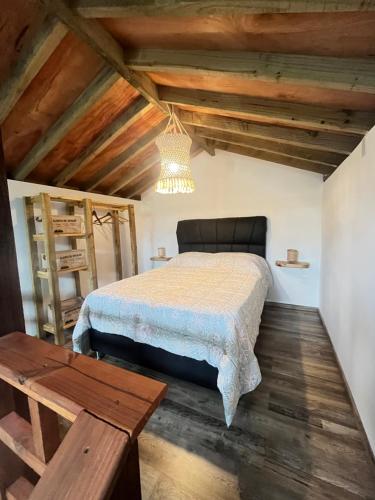 a bedroom with a bed in a room with wooden ceilings at Punta Negra - Cabañas Cacarelhos in Piriápolis