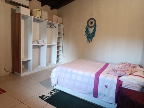 a bedroom with a bed and a shelf at The Mango House in Caaguazú