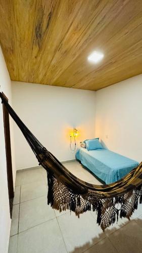 a bedroom with a bed and a hammock in a room at Recanto nas Montanhas em Mulungu in Mulungu