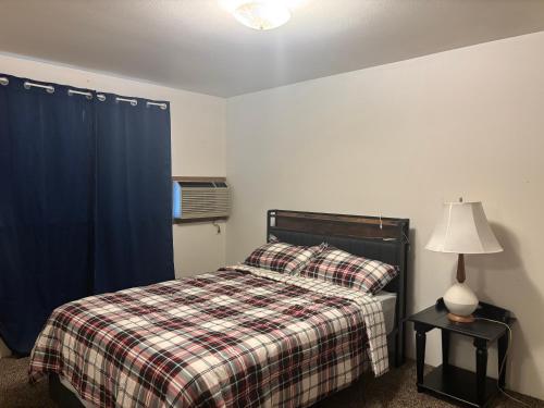 a bedroom with a bed with a plaid blanket at Central Comfort Duplex in Moses Lake