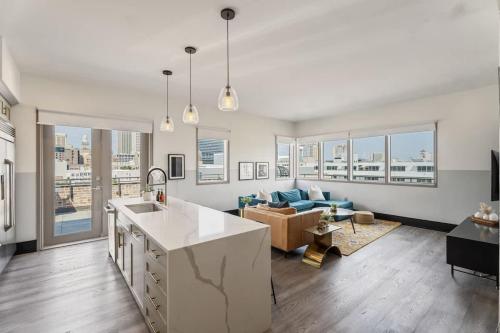 a kitchen and living room with a couch and a table at Corner Penthouse w Private Balcony Hotel Suite in New Orleans