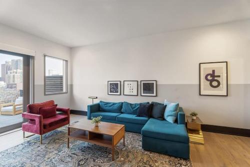 a living room with a blue couch and two chairs at LUX Suite Rooftop Pool Workspace Games Hotel in New Orleans