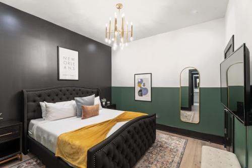 a bedroom with a bed and two mirrors at LUX Suite Rooftop Pool Workspace Games Hotel in New Orleans