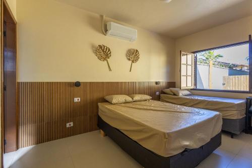 a room with two beds and a window at Vila Tero 400 metros da praia de Boraceia in São Sebastião