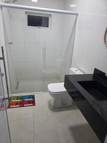 a bathroom with a toilet and a book on the floor at Pousada Vale do Sol in Pariqueraçu