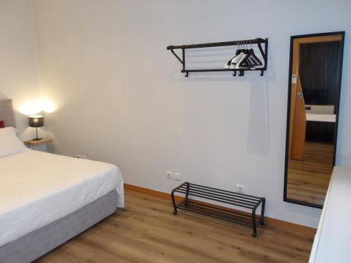 a bedroom with a bed and a bench next to a mirror at Oporto apartment Batalha in Porto