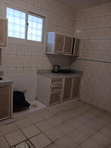 a kitchen with brown cabinets and a window in a room at قصر أبها للشقق المفروشة in Abha