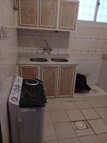 a kitchen with a sink and a trash can at قصر أبها للشقق المفروشة in Abha