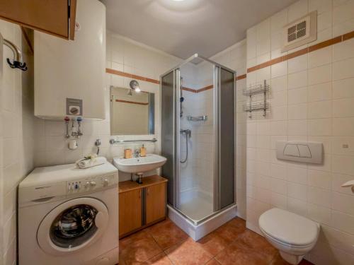 a bathroom with a washing machine and a sink at Salburg Tröpolach in Tröpolach