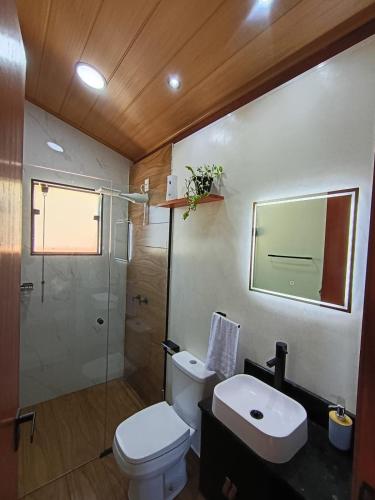 a bathroom with a toilet and a sink and a shower at Sakura da Mantiqueira in Paraisópolis