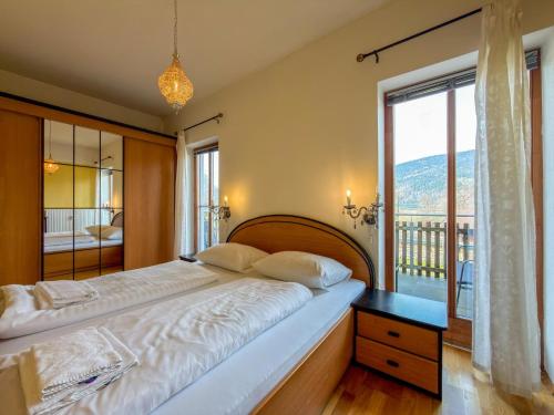 a bedroom with a large bed and a large window at Salburg Tröpolach in Tröpolach