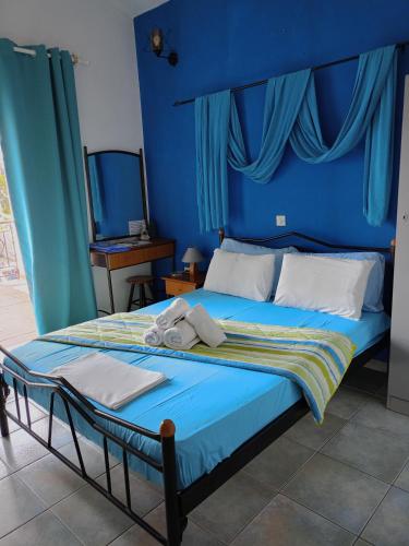 a blue bedroom with a bed with a blue headboard at Villa Nantia in Agios Georgios