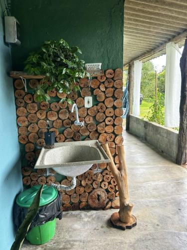 a bathroom with a sink in front of a pile of logs at Encanto da Paz in Miracatu
