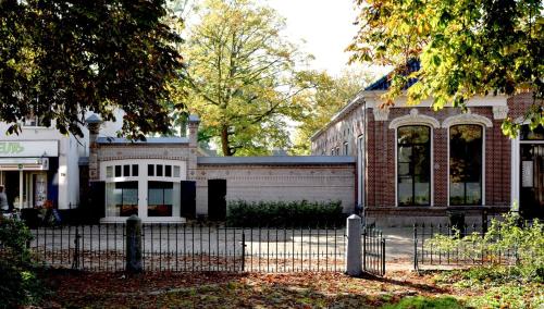 un edificio con una valla delante en Gastenverblijf De Oare Keamer Kollum Friesland, en Kollum